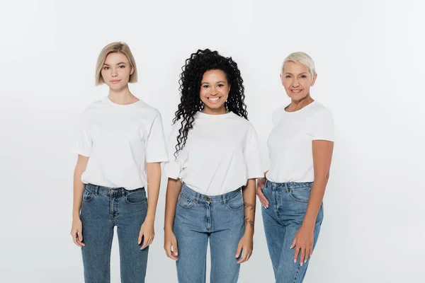 Happy african american woman in white t-shirt standing near friends isolated on grey — Stock Photo