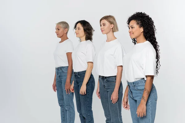 Interracial women in white t-shirts looking away isolated on grey, feminism concept — Stock Photo
