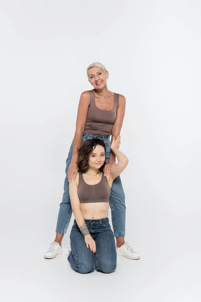 Mujeres alegres posando sobre fondo gris, concepto feminista - foto de stock