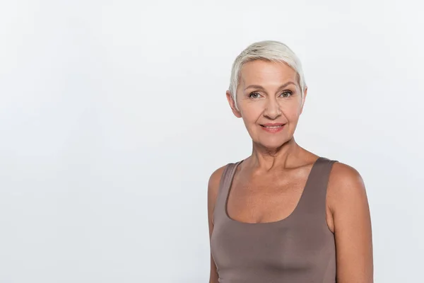 Retrato de mulher de cabelos grisalhos alegre olhando para a câmera isolada no cinza — Fotografia de Stock