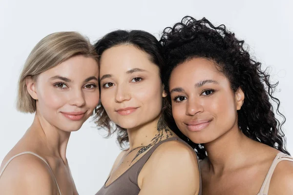 Jóvenes mujeres interracial mirando a la cámara aislada en gris - foto de stock