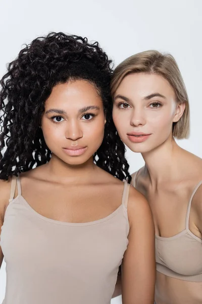 Mulheres loiras e africanas americanas olhando para câmera isolada em cinza — Fotografia de Stock
