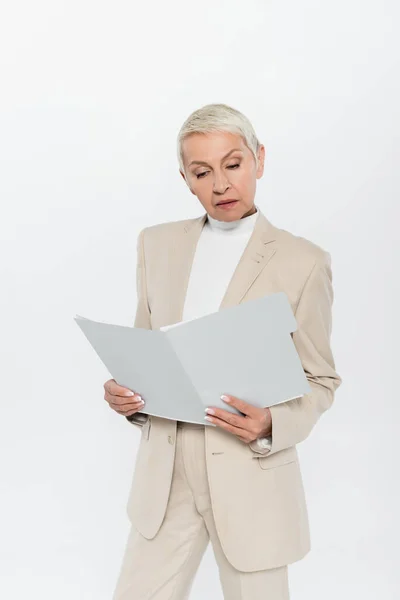 Elderly businesswoman in suit holding paper folder isolated on grey — Stock Photo