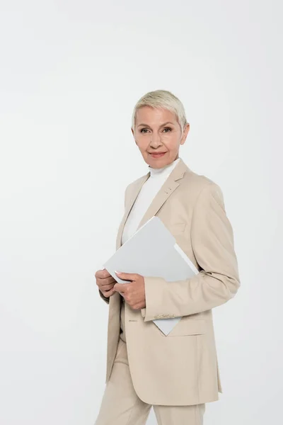 Smiling elderly businesswoman holding paper folder isolated on grey — Stock Photo