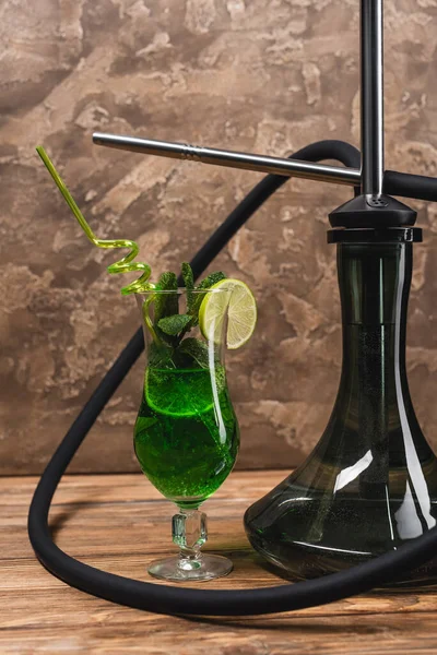 Cocktail near hookah on wooden surface on textured stone background — Stock Photo