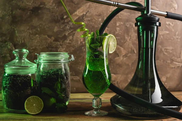 Cocktail, trockener Tee und Wasserpfeife auf Holzoberfläche auf strukturiertem Steinhintergrund — Stockfoto