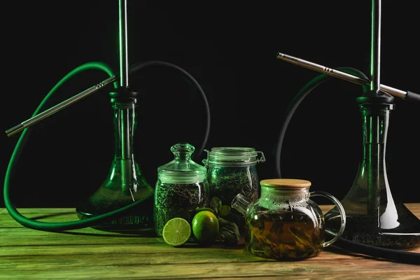 Trockener Tee, Teekanne und Wasserpfeifen auf hölzerner Oberfläche isoliert auf schwarz — Stockfoto