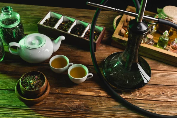 Top view of tea and hookah on wooden surface isolated on black — Stock Photo