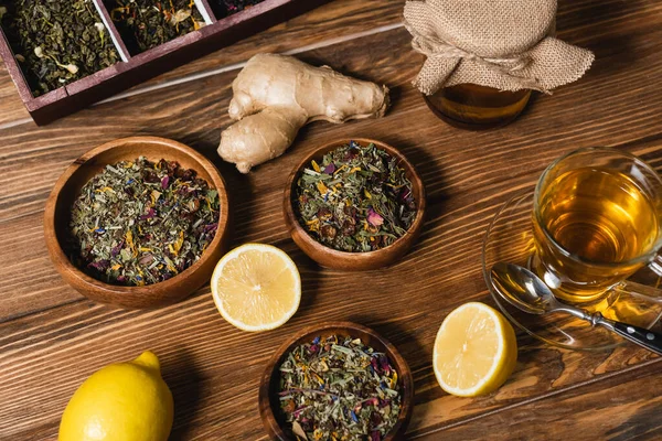 Vista superior del té, limones y miel en la superficie de madera - foto de stock