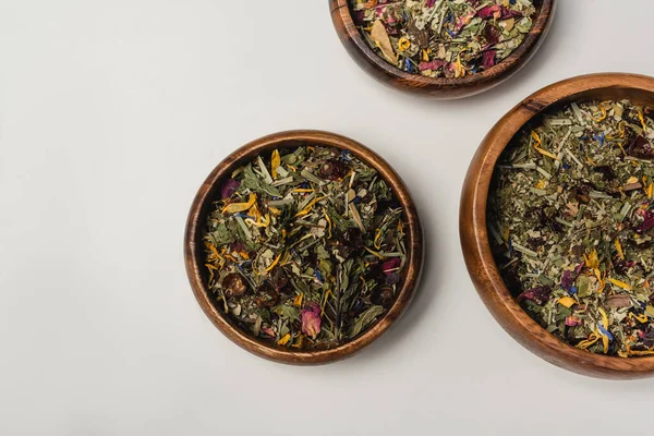 Draufsicht auf trockenen Tee in Holzschalen auf weißem Hintergrund — Stockfoto