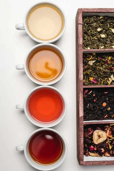 Vista superior de tazas de té y caja de madera sobre fondo blanco — Stock Photo