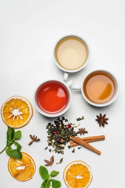 Top view of cups of tea near spices and mint on white background — Stock Photo