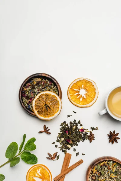 Vista superior de especiarias secas, chá e fatias de laranja no fundo branco — Fotografia de Stock