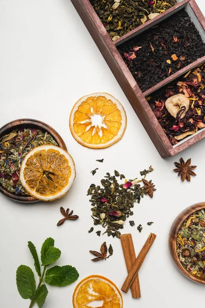 Vista superior del té seco cerca de menta y especias sobre fondo blanco - foto de stock