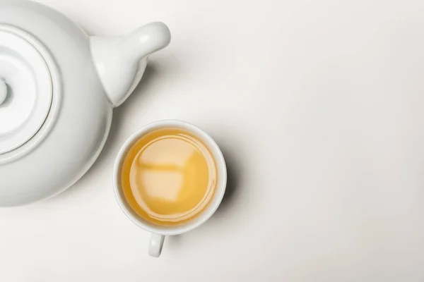 Top view of cup of tea and teapot on white background — Stock Photo