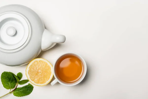 Vue du dessus de tasse de thé, citron et menthe sur fond blanc avec espace de copie — Photo de stock