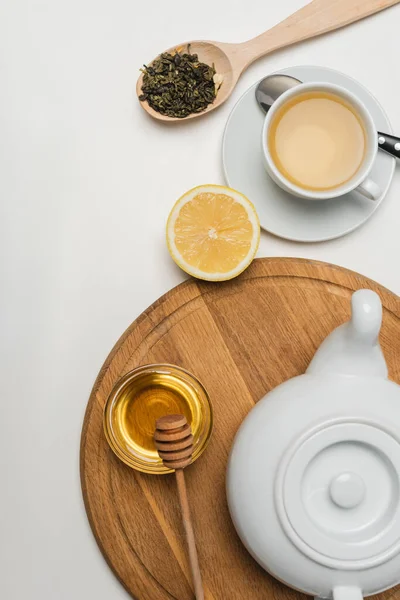 Вид сверху чайника рядом с медом и лемоном на белом фоне — стоковое фото