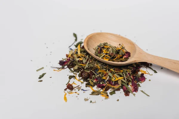 Vista de cerca de la cuchara de madera sobre el té seco sobre fondo blanco — Stock Photo