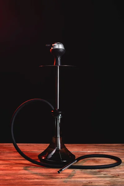 Hookah on wooden surface isolated on black — Stock Photo