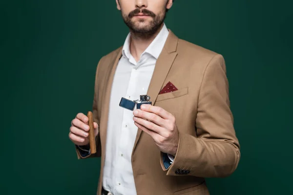 Abgeschnittene Ansicht eines Mannes mit Schnurrbart, der Zigarre und Feuerzeug auf dunkelgrünem Grund hält — Stockfoto