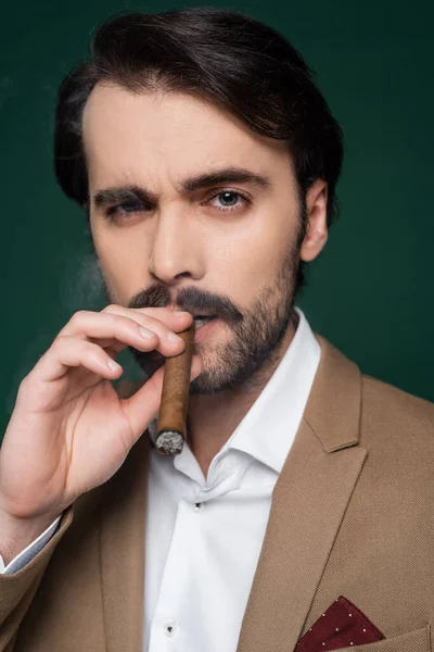 Portrait of man with mustache smiling cigar on dark green — Stock Photo