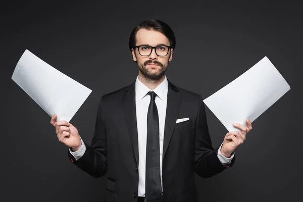 Geschäftsmann mit Schnurrbart in Brille hält Dokumente auf dunkelgrau — Stockfoto