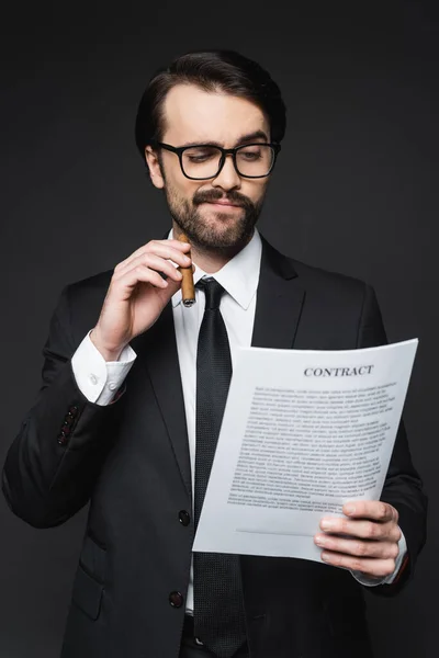 Businessman with mustache holding cigar and contract on dark grey — Stock Photo