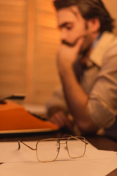 Eyeglasses near blurred writer on background — Stock Photo