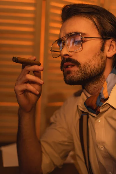 Young man with mustache and eyeglasses smoking cigar — Stock Photo