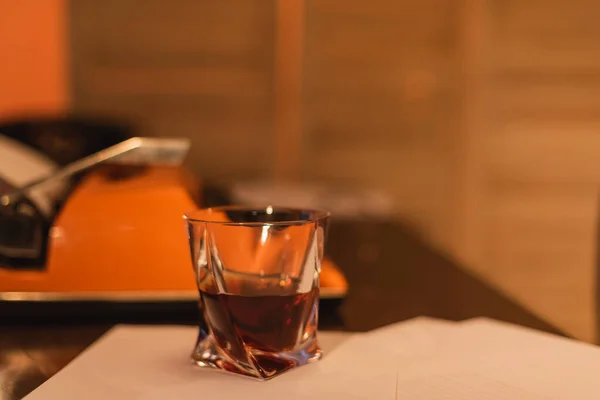 Verre de whisky près de machine à écrire sur le bureau — Photo de stock