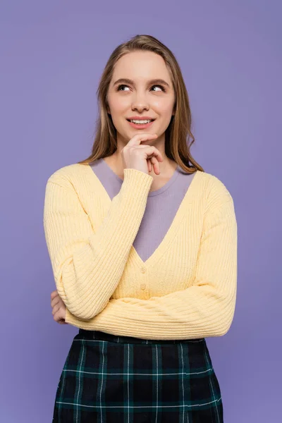 Smiling and young woman looking away and thinking isolated on purple — Stock Photo