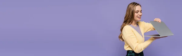 Lächelnder Student mit Laptop auf violettem Banner — Stockfoto