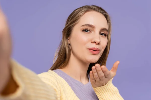Young woman sending air kiss isolated on purple — Stock Photo