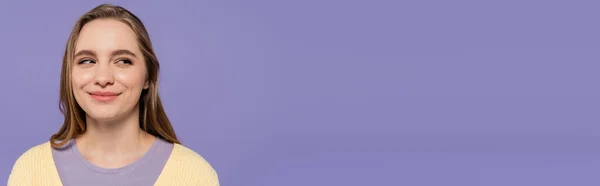 Маленька молода жінка, дивлячись геть і усміхаючись, ізольована на фіолетовому, банер — стокове фото