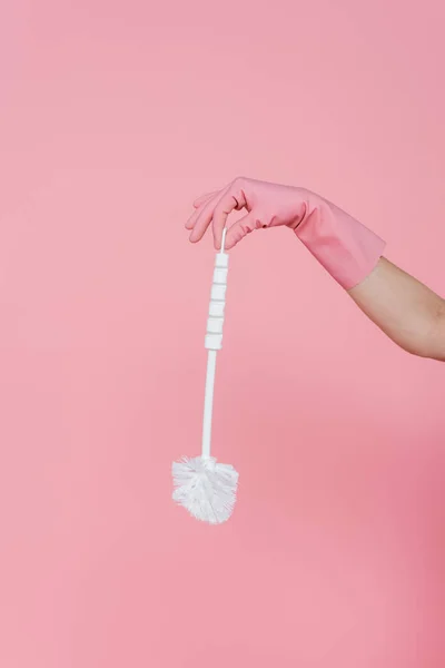 Vista recortada de la mujer en guante de goma con cepillo de inodoro aislado en rosa - foto de stock