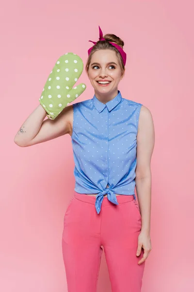 Tätowierte und glückliche junge Frau in grünem Backhandschuh isoliert auf rosa — Stockfoto