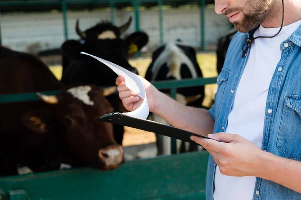 Vue recadrée de l'agriculteur avec presse-papiers près d'étable floue — Photo de stock