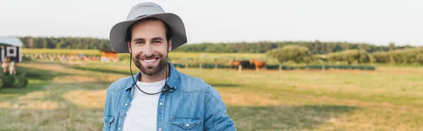 Щасливий фермер, посміхаючись на камеру в зеленому полі на фермі, банер — стокове фото