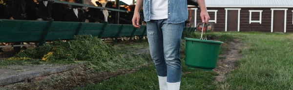 Partial view of farmer with bucket near cowshed on farm, banner — Stock Photo