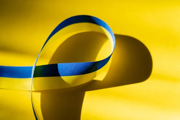 Close up view of blue and yellow ribbon on background with shadow — Stock Photo