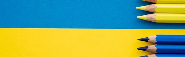 Vue du dessus des crayons de couleur jaune et bleue sur le drapeau ukrainien, bannière — Photo de stock