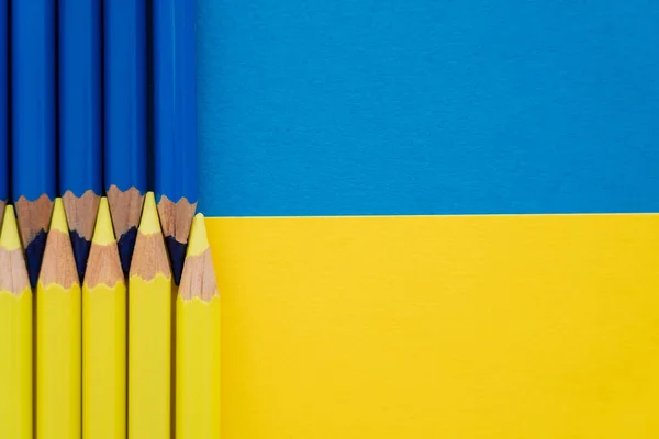 Vista superior de lápis de cor amarelo e azul na bandeira ucraniana com espaço de cópia — Fotografia de Stock