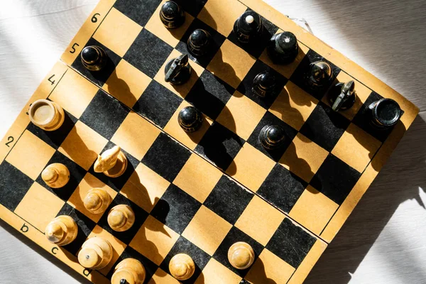 Von oben betrachtet Figuren auf Schachbrett auf Holzgrund — Stockfoto
