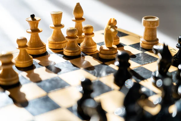 Figuras de xadrez de madeira no tabuleiro de xadrez em fundo cinza — Fotografia de Stock