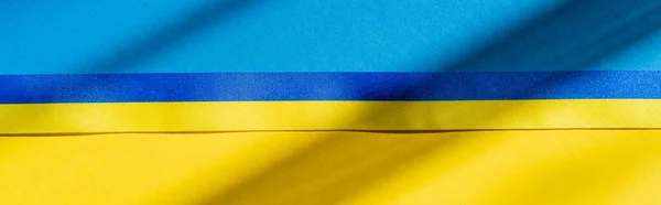 Top view of blue and yellow ribbon on ukrainian flag with shadow, banner — Stock Photo