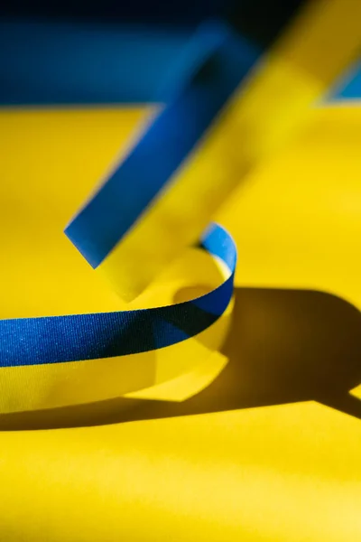 Close up view of blurred blue and yellow ribbon with shadow on ukrainian flag — Stock Photo