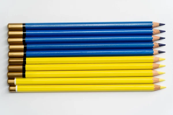 Vue du dessus des crayons de couleur bleu ad jaune sur fond blanc — Photo de stock