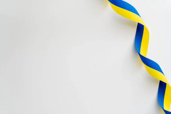 Top view of curly yellow and blue ribbon on white background — Stock Photo
