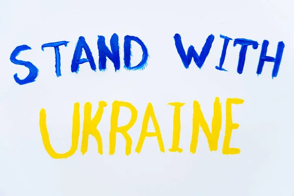 Vista superior del soporte pintado con letras ucranianas sobre fondo blanco - foto de stock