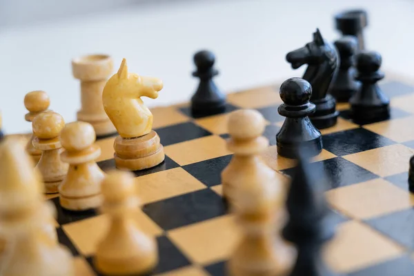 Figures d'échecs en bois sur l'échiquier sur fond blanc — Photo de stock